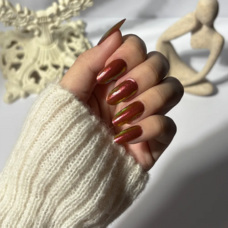 Hand wearing EyeCandys Apple Pie Gel Nail Sticker – glossy red nails with golden chrome iridescence. Festive and cozy DIY gel manicure perfect for Halloween, holiday celebrations, or chic everyday wear. Non-toxic, vegan, and long-lasting salon-quality nails.