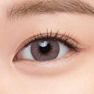 Define Fresh Lilac color contact lens on top of a dark eye paired with subtle eye makeup and curled wispy eyelashes