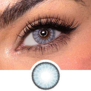 Close-up shot of a model eye wearing Desire Glacier Blue colored contact lens in one eye that is naturally dark-brown with natural rosegold eye make up