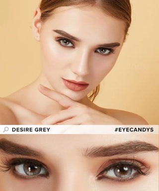 A woman with flawless skin and bold makeup poses with her finger near her lips; below is a close-up of her grey eyes, enhanced by EyeCandys Promotion Desire Series colored contacts. Text reads "DESIRE GREY" and "#EYECANDYS".