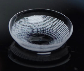 Macro shot of the EyeCandys Dare to be grey prescription colored contact lens on a dark background, showing the detailed pattern of the contact lens design