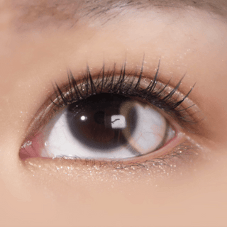 Long-lashed eye wearing EyeCandys Brown Heart contact lens – romantic heart-shaped pattern with subtle limbal ring for a natural yet eye-catching look.