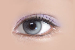 Close-up of eye wearing Eyecandys Bunnie Milky Ash prescription colored contact lens, soft grey tones blending naturally with dark iris