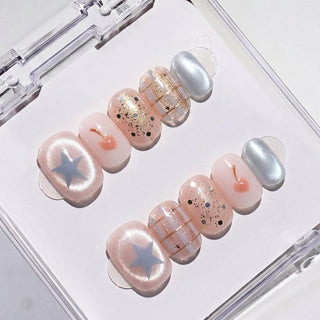 Eyecandys Charmed, I'm Sure press-on nails featuring a sheer nude pink base, playful charm-inspired nail art, chrome accents, and a short round shape.
