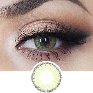 Close-up view of EyeCandys Desire Lush Green color contact lens for astigmatism over a light brown iris, demonstrating color transformation paired with natural eye makeup, next to a cutout of the contact lens