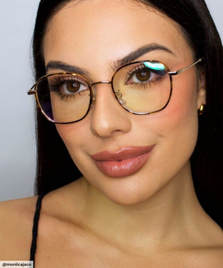 Woman wearing Eyecandys Farrow Round Glasses in tortoiseshell, featuring a vintage-inspired round frame with silver hardware, designed for narrow face shapes like diamond and heart.