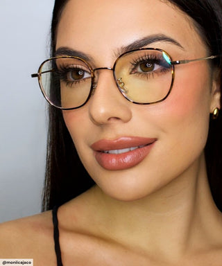 Woman wearing Eyecandys Farrow Round Glasses in tortoiseshell, featuring a vintage-inspired round frame with silver hardware, designed for narrow face shapes like diamond and heart.