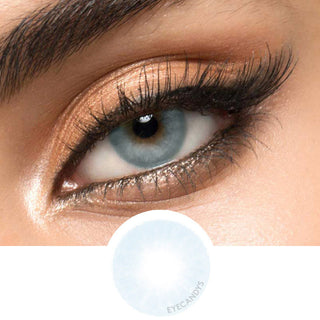 Blue contact lens worn on a brown eye with neutral eye makeup and wispy eyelashes, above the eye contact design on a white background.