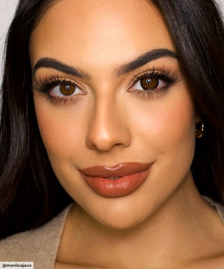 A female model with natural dark eyes wearing Pink Label Vintage brown contact lenses, complemented by subtle eyeshadow and peach lip gloss and Close-up image showcases the model's eyes