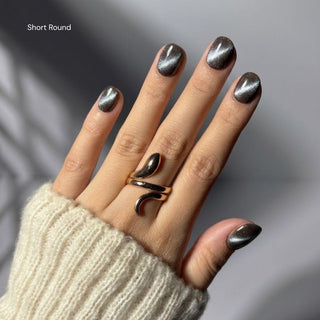 Hand wearing EyeCandys Grapefruit Soda  short round press on nails featuring semi-sheer pink cat-eye nails with soft grapefruit gradient tips.