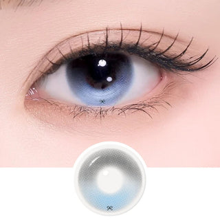 Blue-gray contact lens close-up showcasing a detailed iris pattern, long eyelashes, and matching lens product on a soft pink and white background