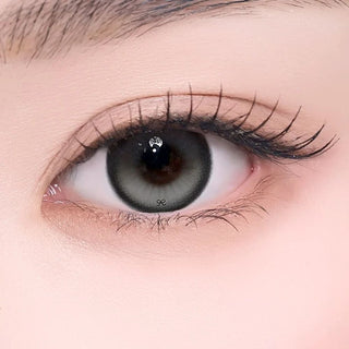 Close-up of an eye wearing a gray-green contact lens with a dark limbal ring and natural-looking gradient