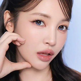 Model with natural makeup and long lashes wearing EyeCandys i-Sha Dekame Kiss Me 1-Day Blue Pop colored contact lenses for a vibrant blue eye look