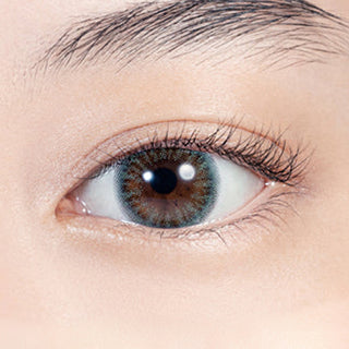 Close-up shot of model's eye adorned with Lilmoon Monthly Ocean (Non Prescription) color contact lenses with prescription, complemented by minimalist eye makeup, showing the brightening and enlarging effect of the circle contact lens on dark brown eyes.