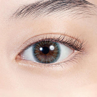 Close-up shot of model's eye adorned with Lilmoon Monthly Ocean (Non Prescription) color contact lenses with prescription, complemented by minimalist eye makeup, showing the brightening and enlarging effect of the circle contact lens on dark brown eyes.