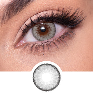 Close-up shot of a model eye wearing Desire Mist Grey colored contact lens in one eye that is naturally dark-brown with natural rosegold eye make up