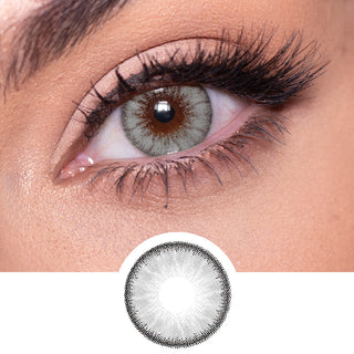 Close-up shot of a model eye wearing Desire Mist Grey colored contact lens in one eye that is naturally dark-brown with natural rosegold eye make up