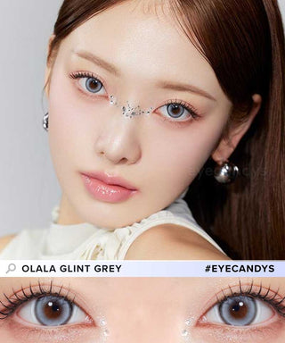 A female model with natural dark eyes wearing Olala Glint grey contact lenses, complemented by subtle eyeshadow and peach lipstick and Close-up image showcases the model's eyes adorned with the same Grey contact lenses