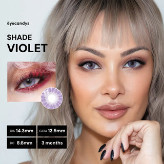 A woman with light blonde hair wears EyeCandys Shade Violet Purple contacts, posing with her hand near her chin. An inset shows a close-up of her eye wearing the lens. Lens specs and the brand name, EyeCandys, are displayed in text.