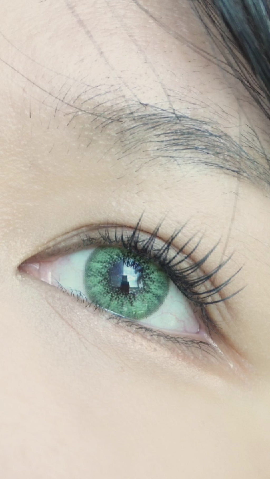 Desire Green prescription colour contact lens worn on a naturally dark iris with natural eyelashes and makeup.