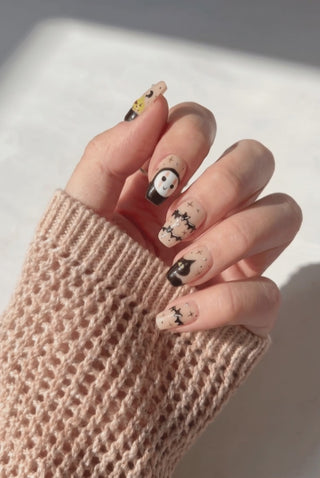 EyeCandys Trick or Chic press-on nails featuring a stylish Halloween-inspired manicure on a hand