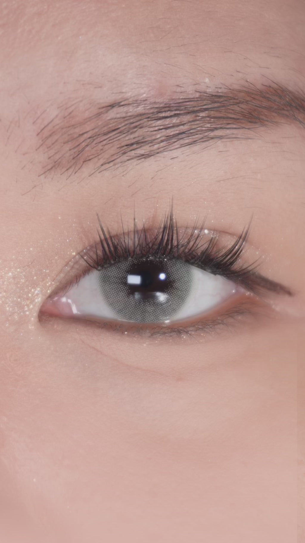 Brown eye with long lashes featuring EyeCandys Glossy Ivory color contact lens