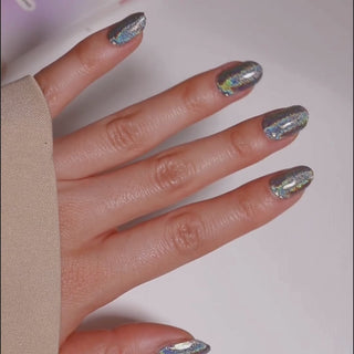 Model's hand showcasing EyeCandys Cosmic Gel Nail Stickers. These silver glitter stickers add a sparkling, glamorous touch to your nails, offering a glossy, long-lasting finish for a chic and festive look.