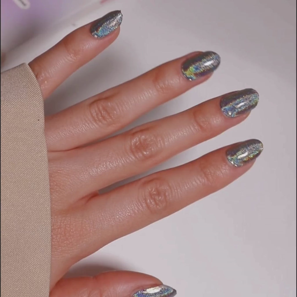 Model's hand showcasing EyeCandys Cosmic Gel Nail Stickers. These silver glitter stickers add a sparkling, glamorous touch to your nails, offering a glossy, long-lasting finish for a chic and festive look.