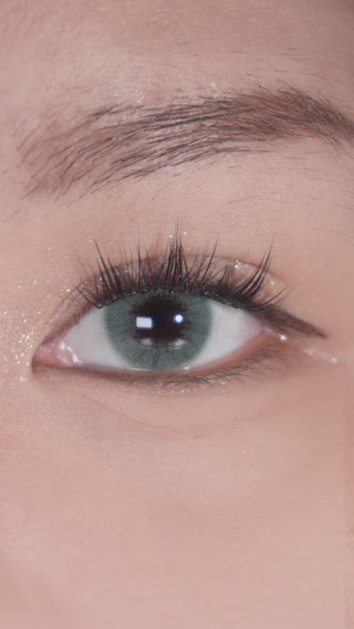 Eyes with long lashes wearing EyeCandys Glossy Green prescription colored contact lenses, blinking naturally