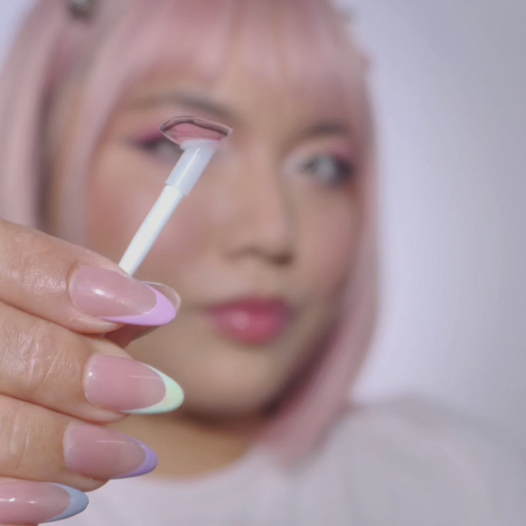 Video of model wearing EyeCandys Powerglow Reddish Pink colored contact lenses. Full face and close-up showcasing ultra-vibrant red-pink iris, long lashes, defined limbal ring, and bold cosplay-ready eye transformation.