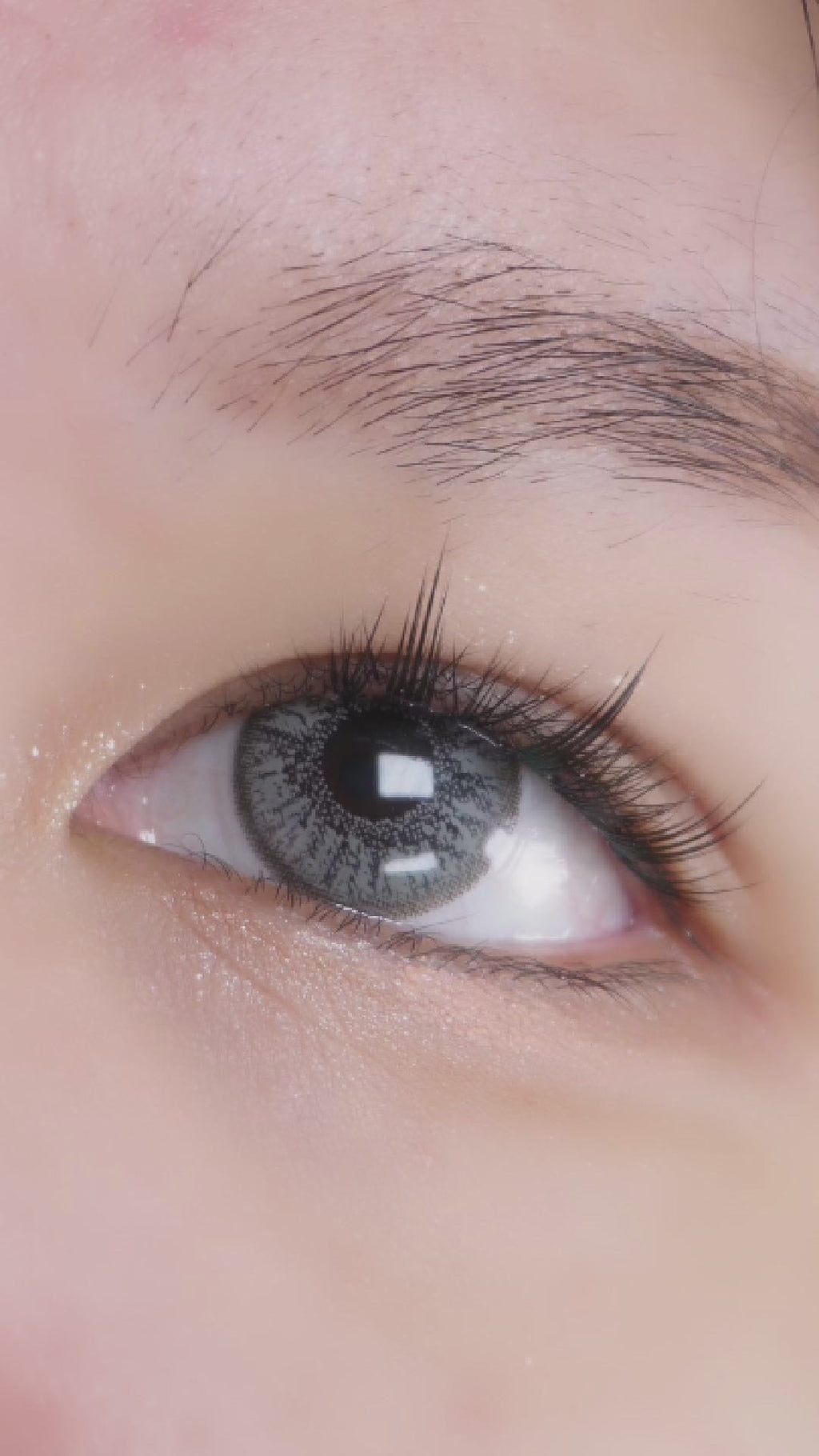 Model trying on eyelighter grey contact lenses for astigmatism, showing the transformative effect of the before/after contact lens, paired with subtle korean inspired eye makeup