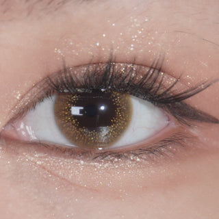 Prescription EyeCandys Attitude Glitter Brown contact lens worn on eye, close-up view with blinking.
