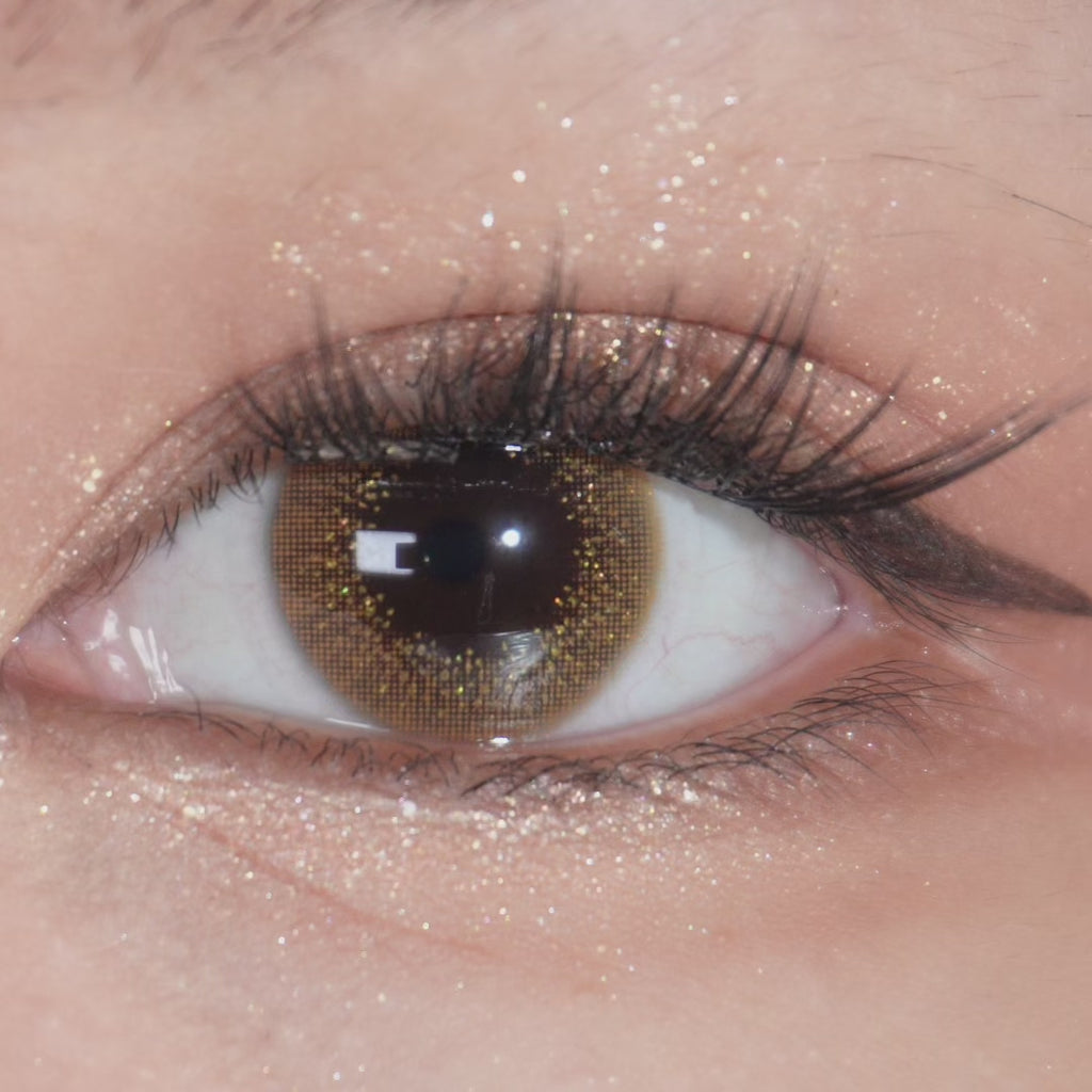 Prescription EyeCandys Attitude Glitter Brown contact lens worn on eye, close-up view with blinking.