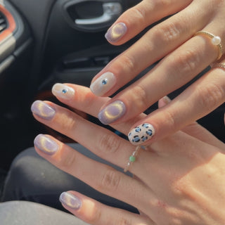 Wearing EyeCandys Purr-ple Reign Press-On Nails, soft lilac cat-eye base with magnetic shimmer and gold leopard accents in a squoval shape