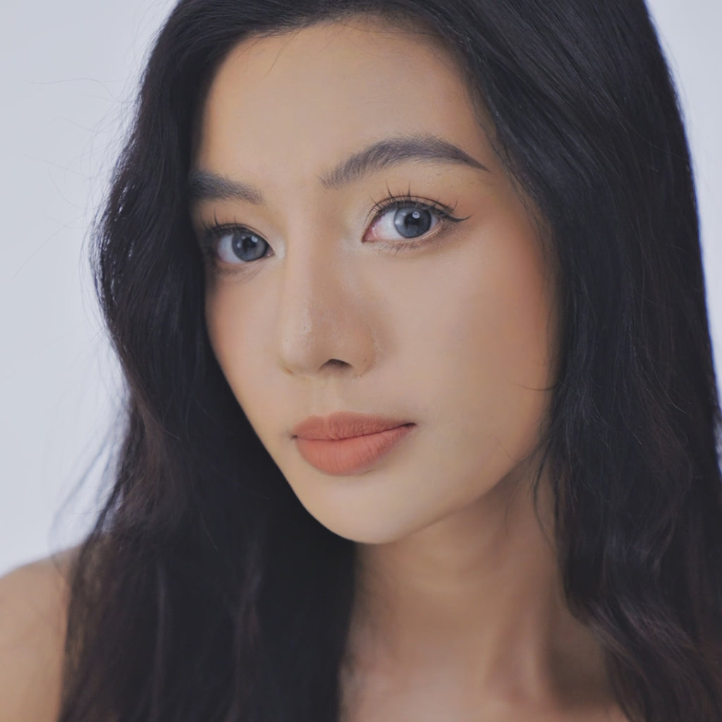 Video of a model wearing EyeCandys Bunnie Milky Ash Grey prescription colored contact lens, highlighting soft grey tones and natural eye enhancement.