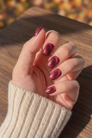 EyeCandys Ruby Slipper press-on nails featuring a sparkling red manicure on a hand