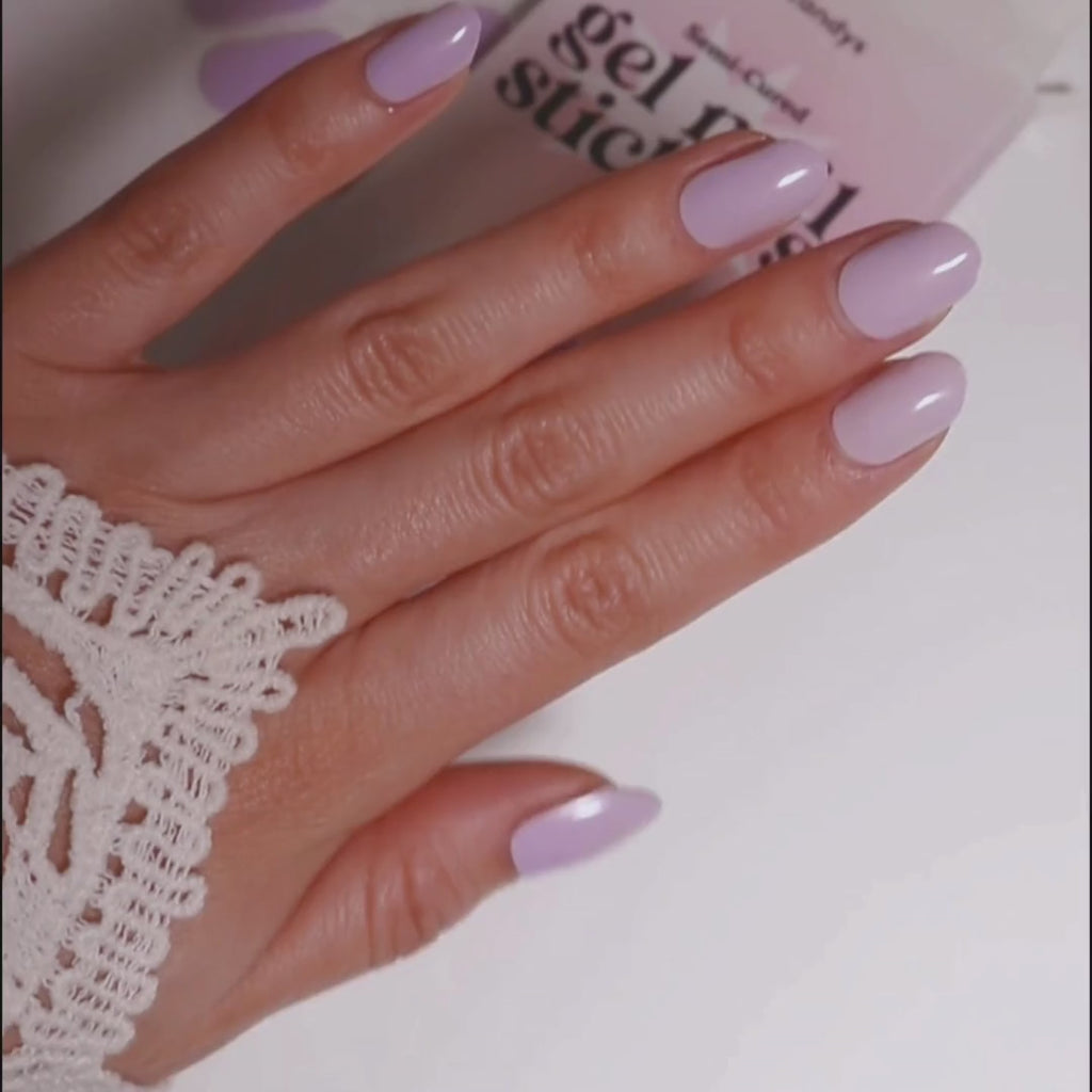 Model's hand showcasing EyeCandys French Lavender Gel Nail Stickers. These soft lavender-colored stickers offer a delicate, elegant look with a glossy finish, providing a long-lasting, chip-free manicure for a sophisticated and fresh touch to your nails