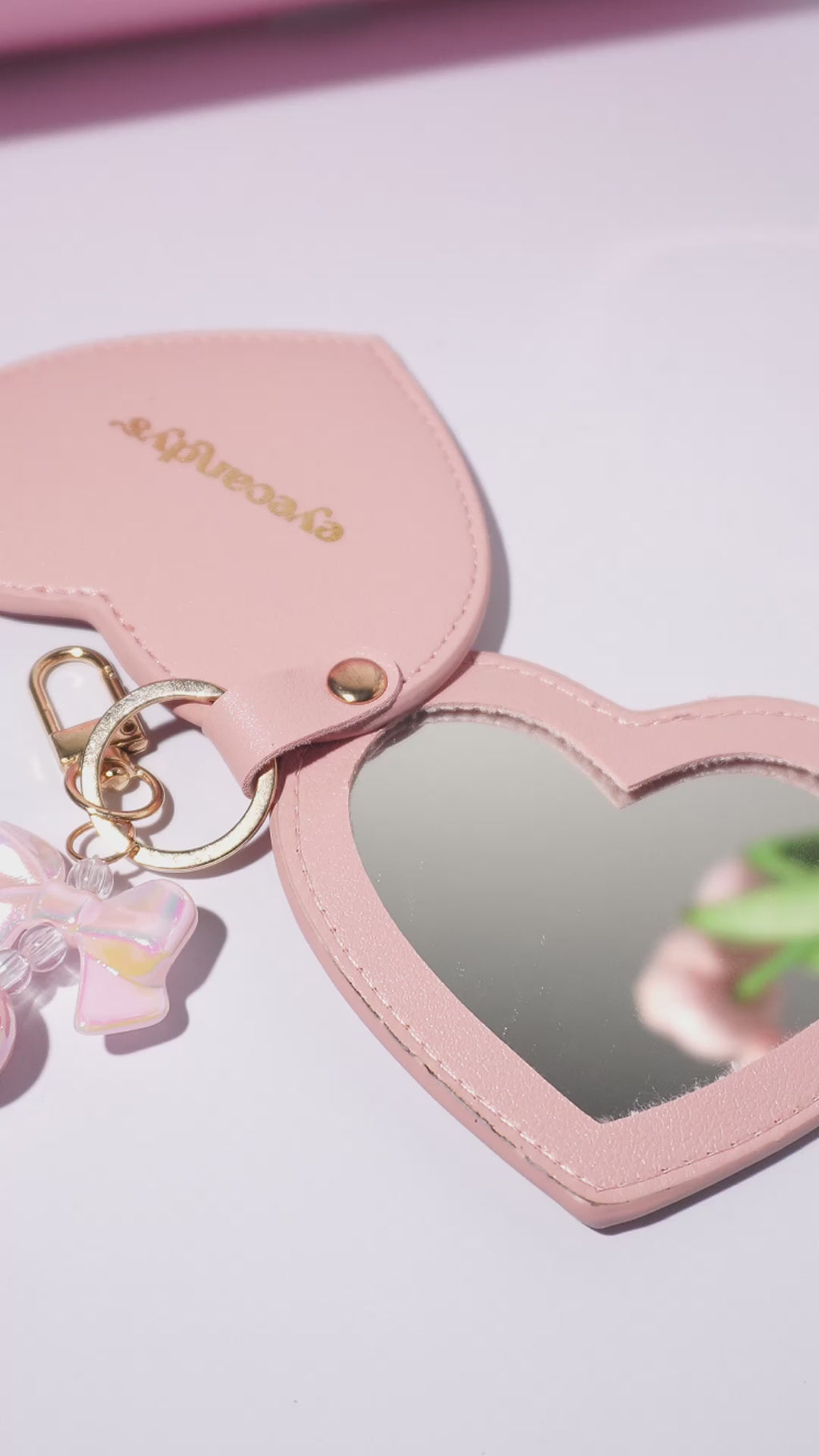 Video showcasing EyeCandys heart-shaped compact mirror, perfect for makeup touch-ups and on-the-go beauty essentials