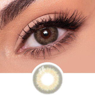 Close-up view of EyeCandys Sugarlook brown contact lens on a model's dark eye, paired with natural eye makeup, above the graphic design of the brown eye contacts.