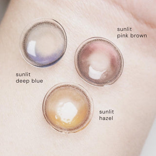 Sunlit series color contact lenses in pink, hazel and blue, photographed on a wrist