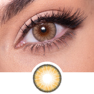 Close-up shot of a model eye wearing Desire Toffee Brown colored contact lens in one eye that is naturally dark-brown with natural rosegold eye make up