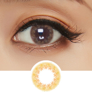 Close-up shot of model's eye adorned with Truffle Brown colored contacts for astigmatism, complemented by clean eye makeup, showing the brightening effect of the brown contact lens on dark brown eyes, above a cutout of the brown circle lens with limbal ring.