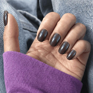 Hand wearing EyeCandys Vino Tinto Press-On Nails in pearlescent vino-tinto burgundy with a garnet metallic glow, short oval gel press on nails perfect for fall and winter.
