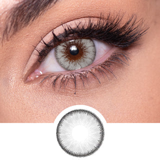 Close-up shot of a model eye wearing Desire Innocent White Grey colored contact lens in one eye that is naturally dark-brown with natural rosegold eye make up