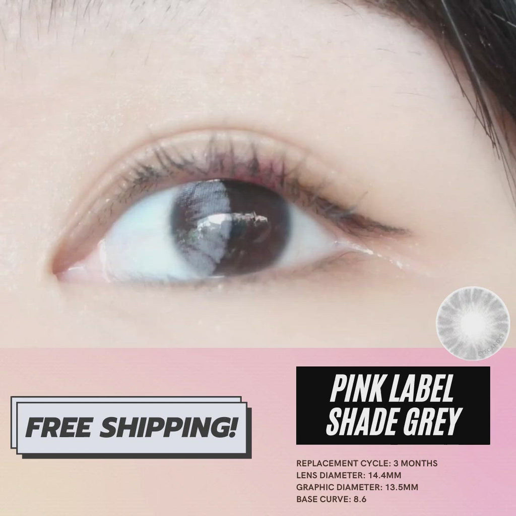 Grey contact lens sliding onto an eyeball with a dark iris of an Asian model