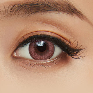 Close-up shot of model's eye adorned with Acuvue 1-Day New Define Fresh Rose color contact lens dailies, complemented by clean eye makeup, showing the brightening effect of the pink contact lens on dark brown eyes.