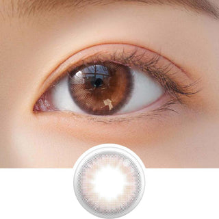 Close-up shot of model's eye adorned with Chuu Cloud Pudding Pink Brown (10pk) daily color contact lenses with prescription, complemented by clean eye makeup, showing the brightening and enlarging effect of the circle contact lens on dark brown eyes, above a cutout of the contact lens pattern with limbal ring on a white background.
