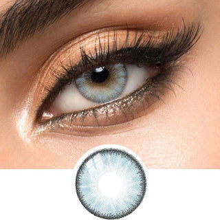 Close-up shot of a model eye wearing Desire Glacier Blue colored contact lens in one eye that is naturally dark-brown with natural ligth gold eye make up