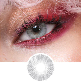 Shade Grey prescription colored contact lens overlaid on a light brown iris, paired with red eyeshadow and curled eyelashes, on a model with pink hair.