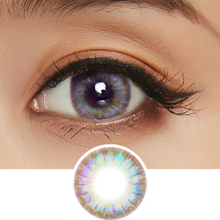 Close-up view of a model's eye featuring Rio Brown color contact lens with prescription, paired with neutral eye makeup, above a cutout of the contact lens showcasing the detailed starburst design.